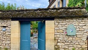 A stone building with a blue door and a small plaque on the wall. - Maison Chaumont: Quiet Retreat with Chateau Views (Vézac)