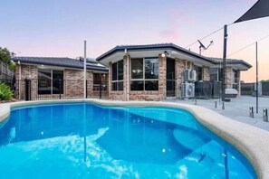 A swimming pool with a house in the background. - Fully AC 3-bedroom apartment with swimming pool and 3 parking spaces (Mansfield)