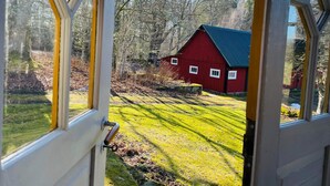 A view through a window of a red barn in a rural setting. - 6 Person Holiday Home in Backaryd (Backaryd)