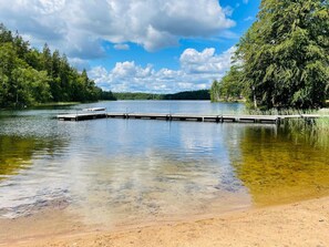 A calm lake with a wooden dock extending into the water, surrounded by dense trees. - 6 Person Holiday Home in Backaryd (Backaryd)