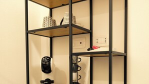 A black metal shelving unit with wooden shelves against a white wall. - Saludu Boutique (Porto Torres)
