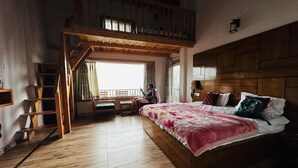 A room with a wooden bed, a loft area, a desk, and a window with curtains. - B'NEST By Baan Home Stay (Siloti Pant)
