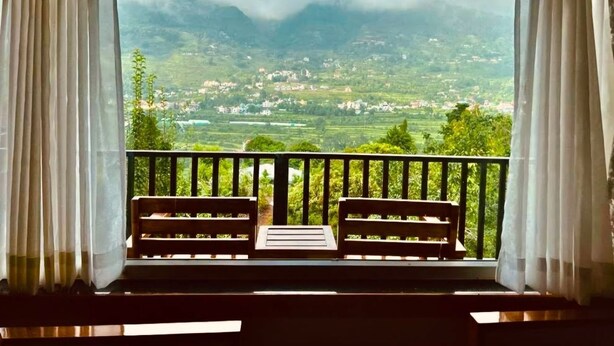 A balcony with two wooden benches and a view of a mountainous landscape. - B'NEST By Baan Home Stay (Siloti Pant)
