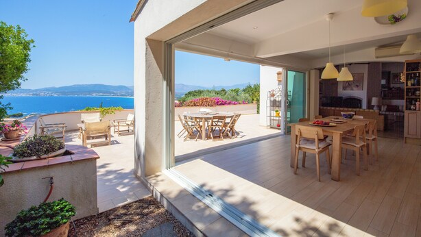 Une cuisine moderne avec des meubles en bois et un coin repas comprenant une table et des chaises.