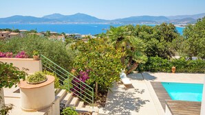 Une piscine située sur le toit, offrant une vue sur la mer et les montagnes.