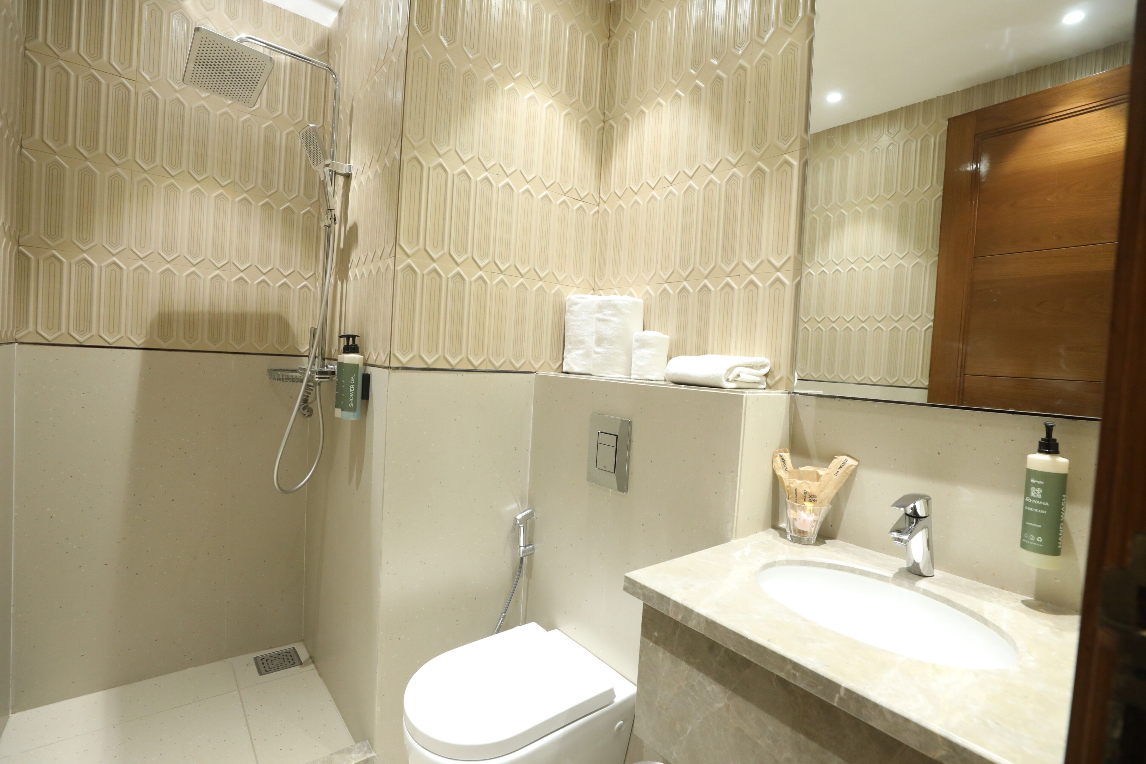 Une salle de bain équipée d’une douche, de toilettes, d’un lavabo et d’un miroir.