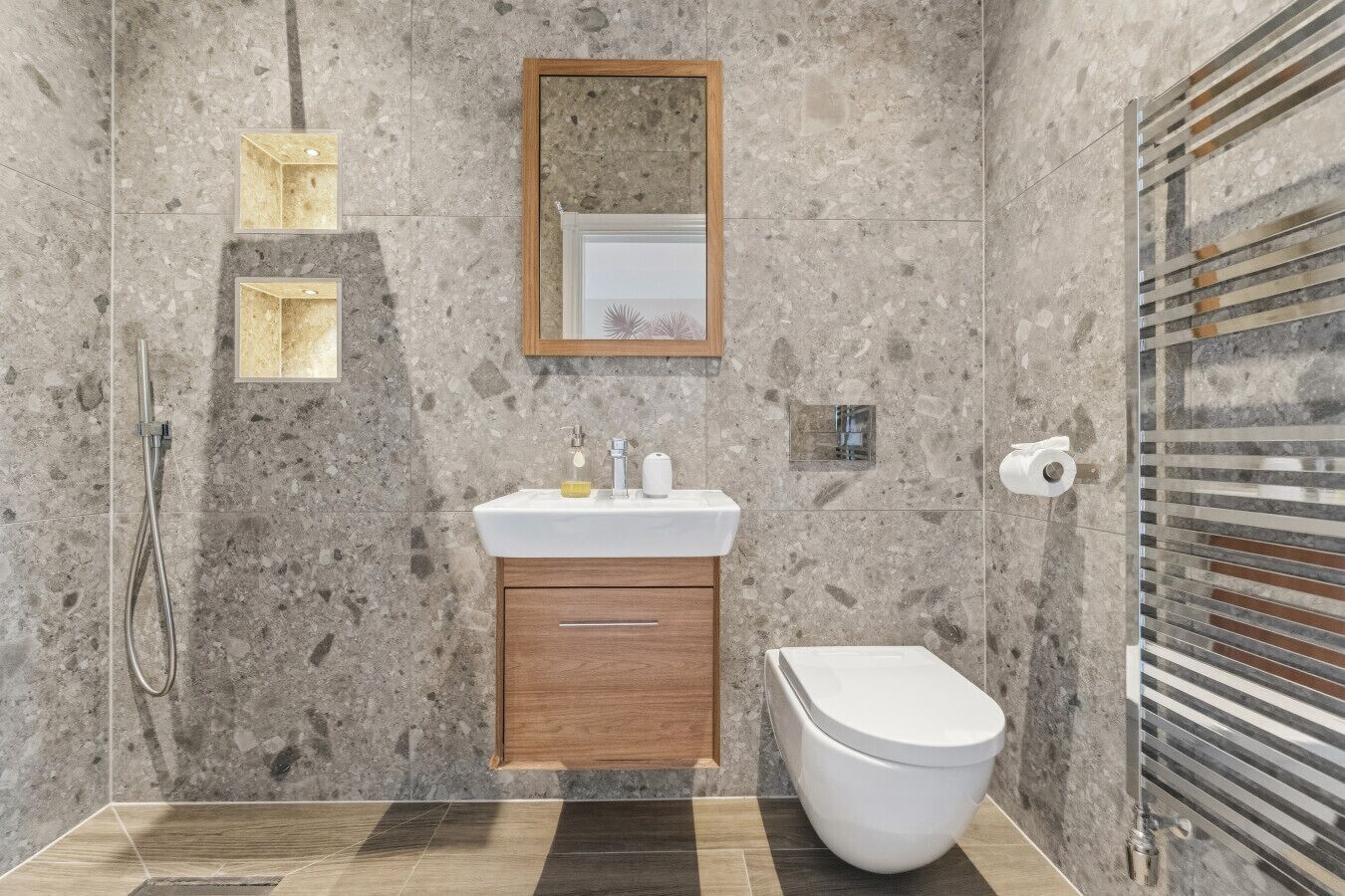A bathroom with a shower, sink, mirror, and toilet.