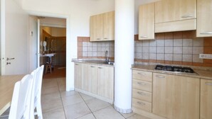 A kitchen with light wooden cabinets, a tiled backsplash, and a gas stove. - Studio for Couples in Capo Vaticano With Pool (Ricadi)