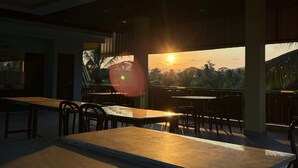 A spacious outdoor dining area with a view of the sunset. - Sri Krish Resort  (Port Blair)