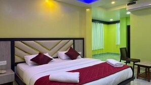 A modern hotel room with a large bed, a desk, and a chair. - Sri Krish Resort  (Port Blair)
