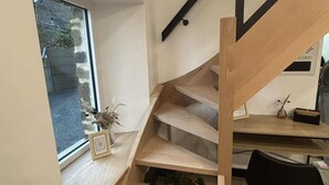 Un escalier moderne avec des marches en bois et une rampe en verre.