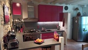 A kitchen with a gas stove, sink, and modern appliances. There is a fruit bowl on the counter and a toaster. - Charming house with swimming pool near Saint Emilion (GARDEGAN ET TOURTIRAC)