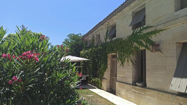 A courtyard with a building featuring a tiled roof, a door, and a window. - Charming house with swimming pool near Saint Emilion (GARDEGAN ET TOURTIRAC)