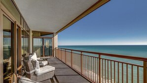 En balkon med fletmøbler og havudsigt.