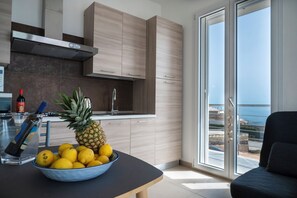 Eine moderne Küche mit einem großen Fenster, einem Essbereich mit Tisch und Meerblick.
