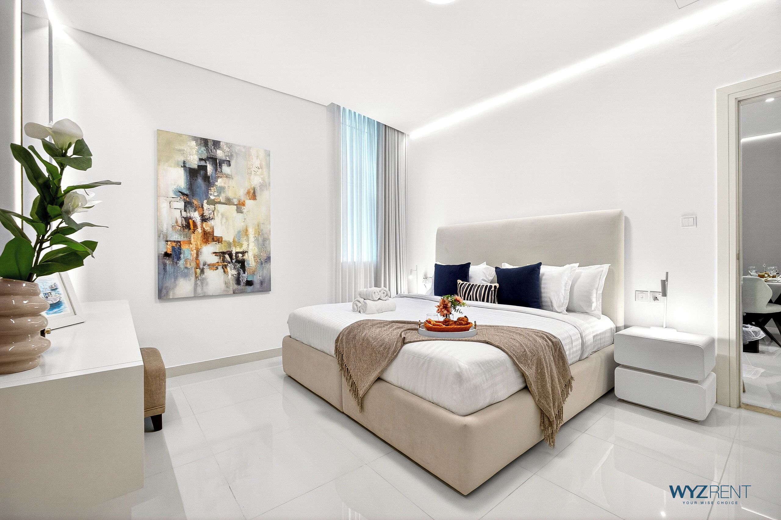Un dormitorio moderno con una cama grande, mesitas de noche, una lámpara de noche y un cuadro en la pared.