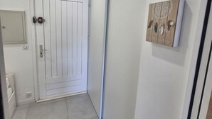 Un pasillo con una puerta blanca, una puerta corredera y un adorno en la pared.