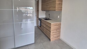Una cocina moderna con armarios de madera, horno empotrado y un ventanal grande.
