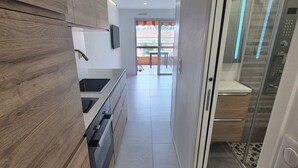 Una cocina moderna con armarios de madera, horno empotrado y un amplio ventanal.