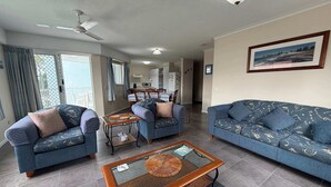 Een woonkamer met twee banken, een salontafel en een eethoek met stoelen en een tafel.