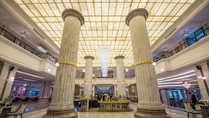 A spacious lobby with marble columns, a high ceiling with a grid pattern, and a reception desk. - Vinpearl Resort And Spa Ha Long (Ha Long)