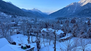 A snow-covered village with houses and mountains in the background. - The Riviera Hotel Pahalgam (Pahalgam)