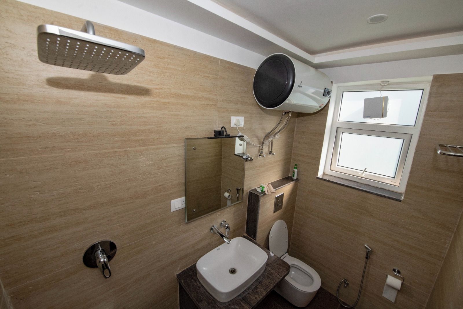 A bathroom with a shower, toilet, sink, and a mirror.