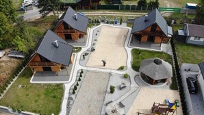 A residential area with multiple houses, a central open space, and a playground. - Holiday Homes With Fireplaces, Playground (Lubrza)
