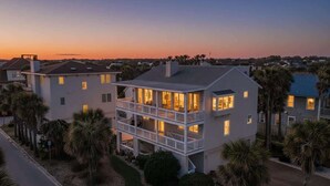 A two-story residential building with a balcony, surrounded by palm trees and a clear sky. - Spanish Villa - Sleeps 12 (Jacksonville Beach)