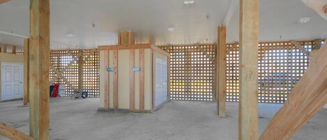 A spacious indoor area with exposed wooden beams, a concrete floor, and a partially constructed wall with a door labeled '3206'.