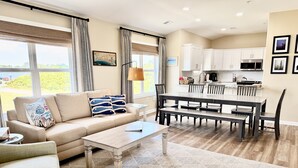 Una sala moderna con sofá, mesa de centro y comedor con sillas y una mesa.