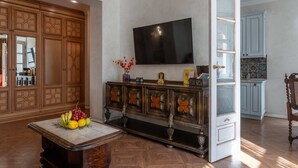 Una sala de estar con un aparador de madera, un televisor y un frutero.