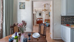 Comedor con una mesa para dos, un candelabro y vista a un dormitorio.