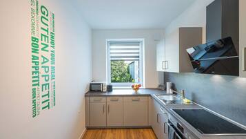 A modern kitchen with a built-in oven, a microwave, and a sink.