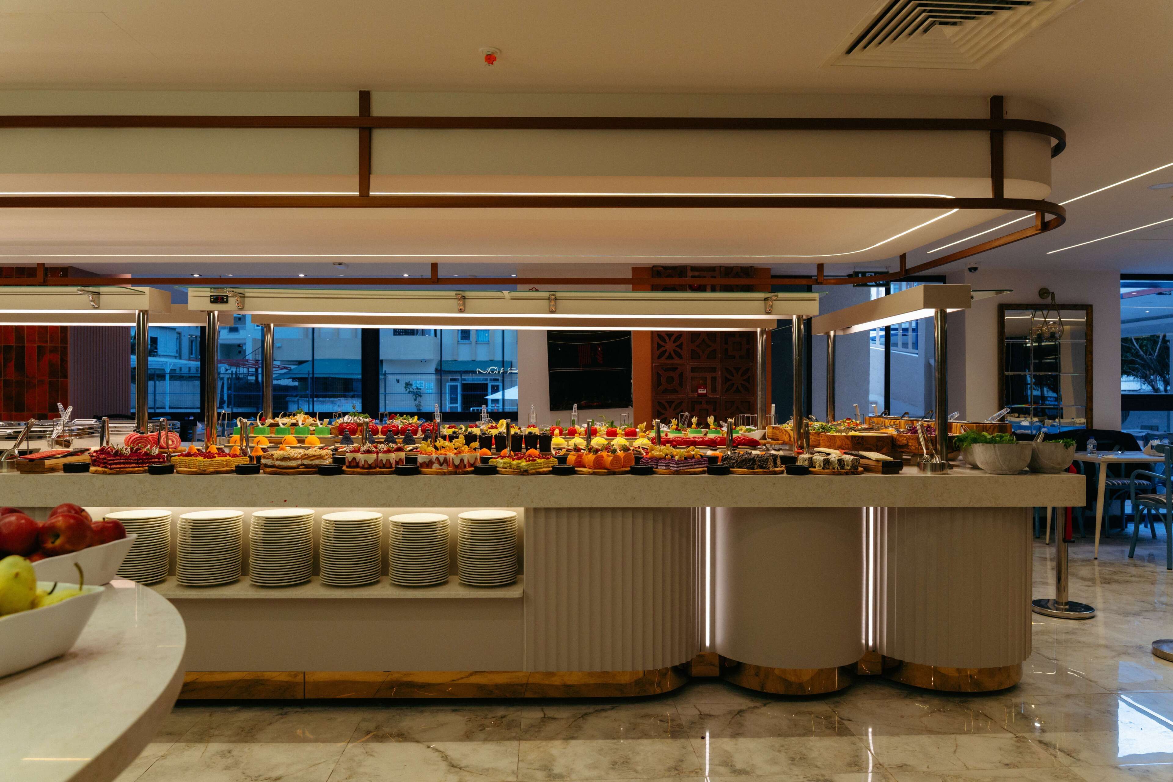 A buffet with various food items and a fruit bowl.