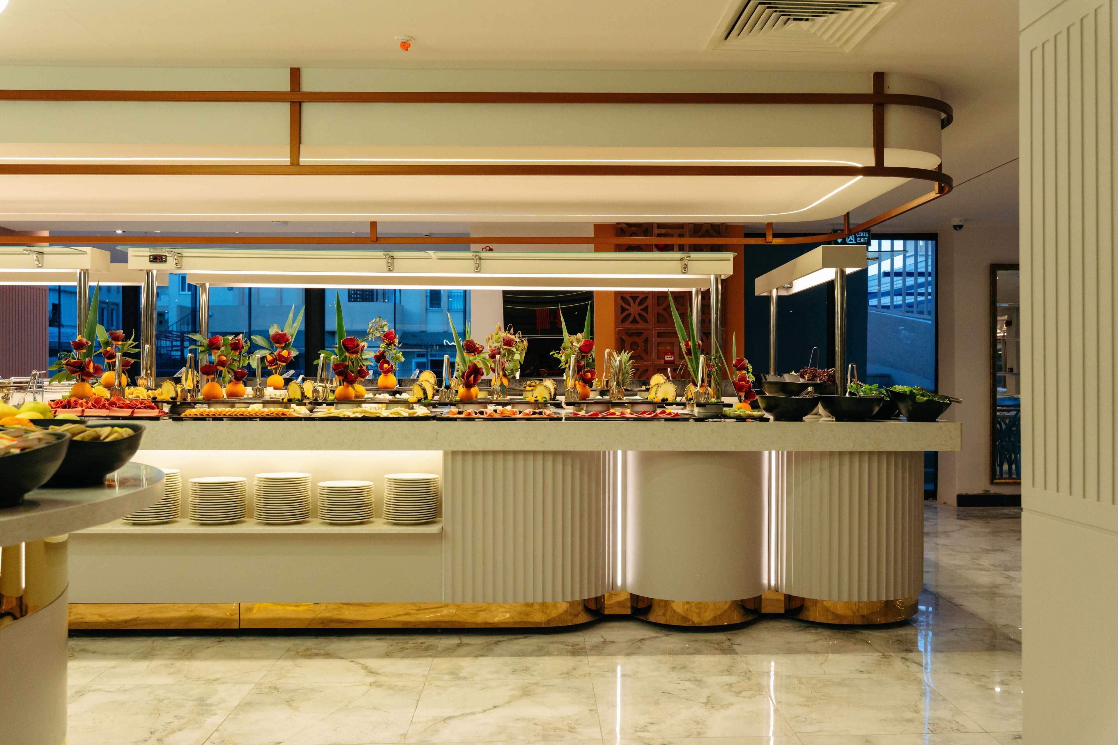 A buffet with various fruits and vegetables, a marble floor, and a modern interior design.