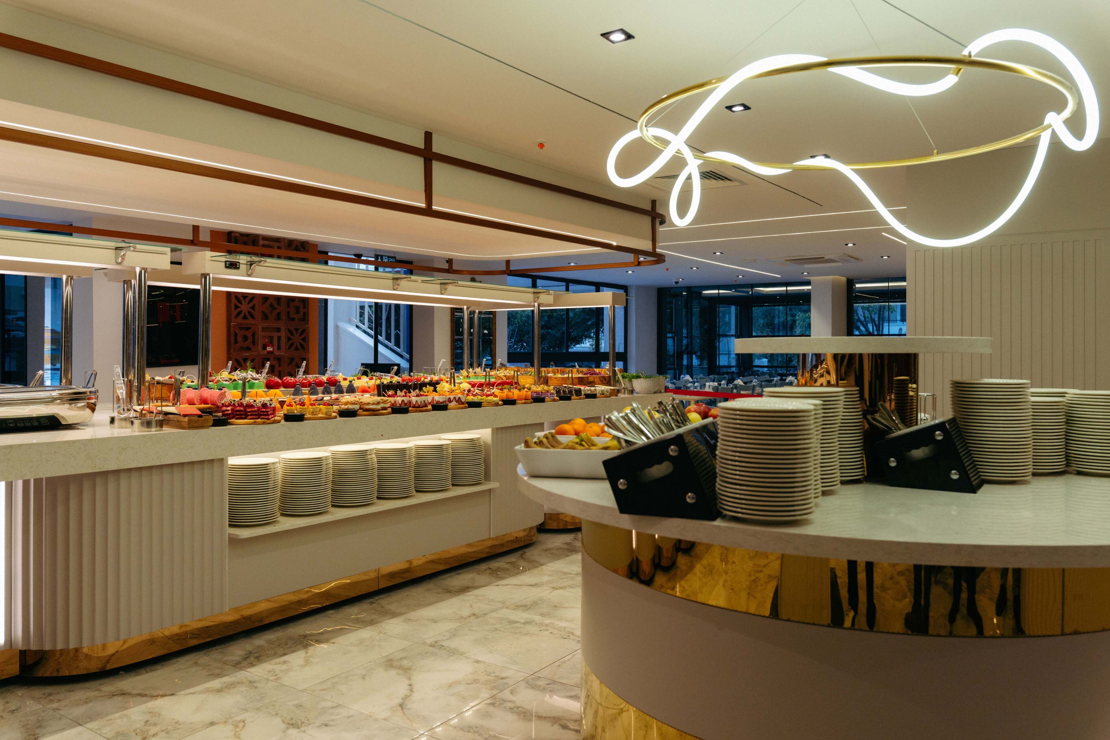 A buffet area with a variety of food items, plates, and serving utensils.