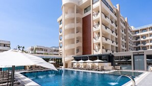 Un hôtel doté d’une piscine, de plusieurs balcons et d’un espace restaurant.