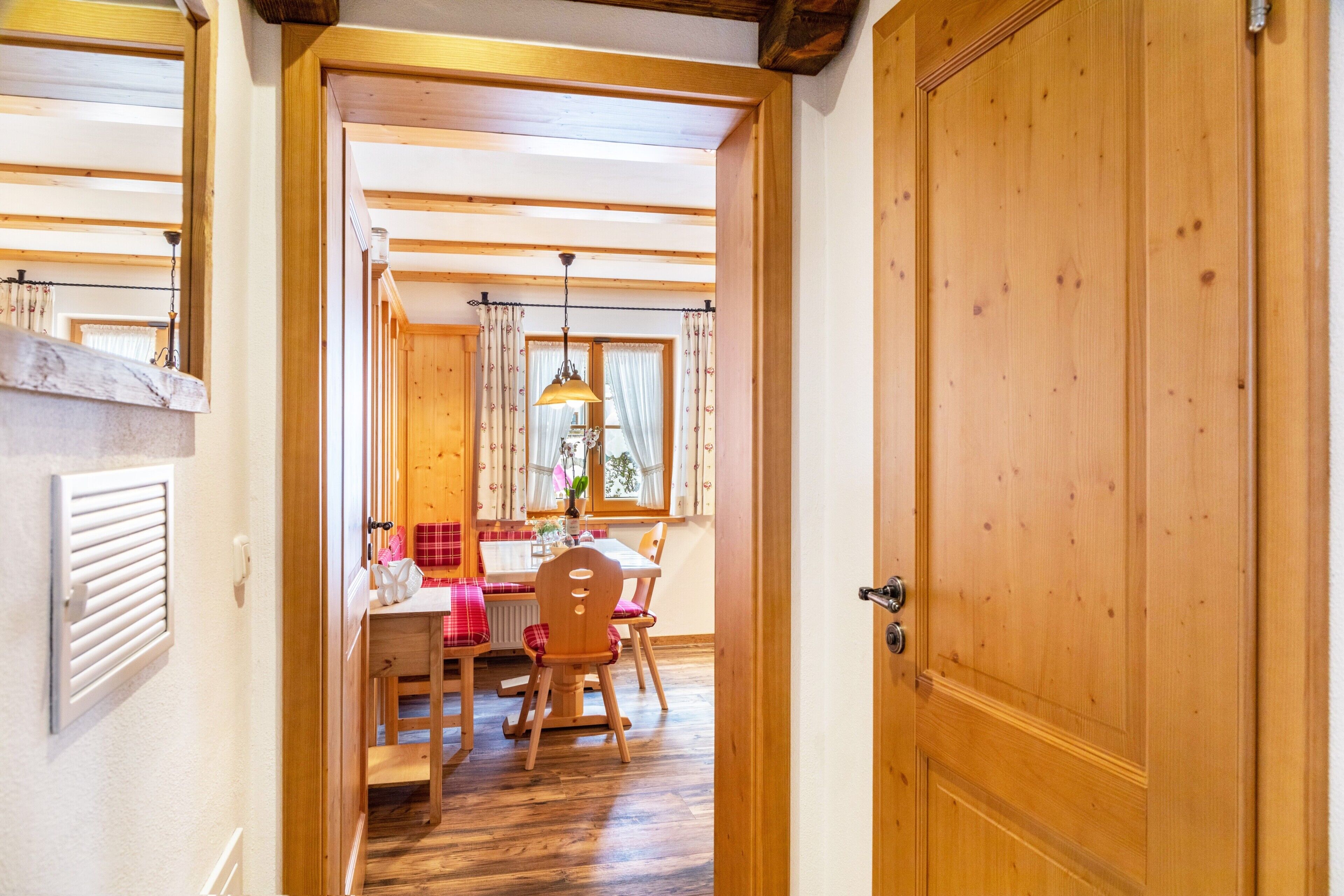 Ein Holzinterieur mit Essbereich, einer Tür und einem fensterbepflegten Fenster.