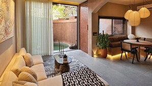 Una sala de estar moderna con un sofá, una mesa de comedor y un ventilador de techo.