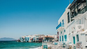 A seaside terrace with white buildings, blue accents, and stone flooring. - Eidolion Essence Nest - Mykonos Cozy Getaway (Mykonos)