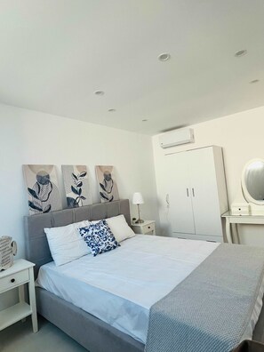 A modern bedroom with a bed, bedside tables, a wardrobe, and wall art. - Eidolion Essence Nest - Mykonos Cozy Getaway (Mykonos)