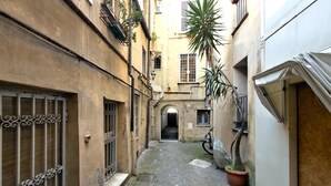 Un estrecho callejón adoquinado entre edificios con ventanas protegidas por rejas, y una bicicleta estacionada a la derecha.