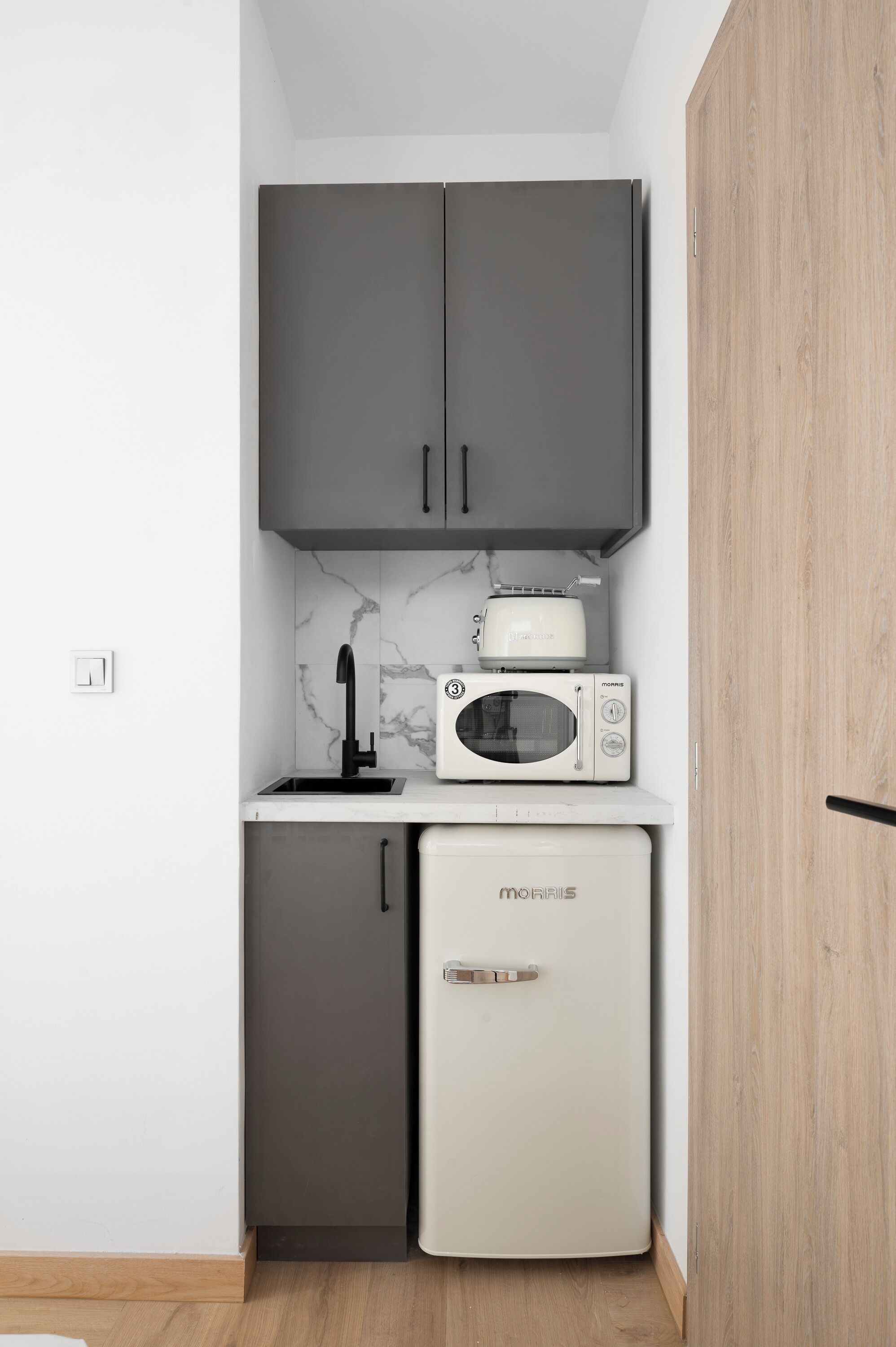 A compact kitchenette with a microwave, toaster, and refrigerator.