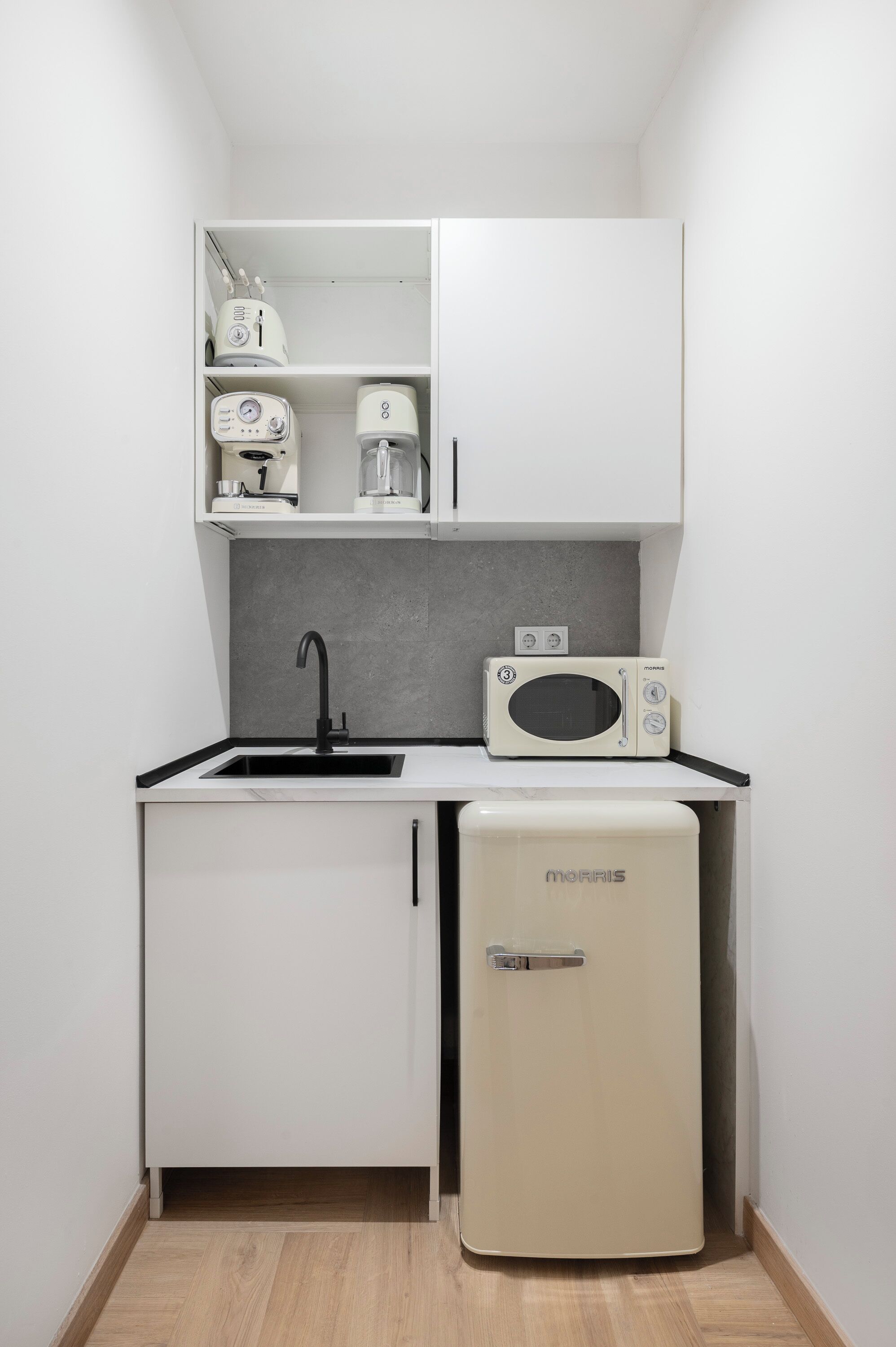 A compact kitchen with a sink, a microwave, and a refrigerator.