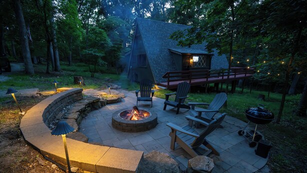 A circular fire pit with seating, a barbecue grill, and a covered deck area. - White Oak Hollow - newly updated (Innsbrook)