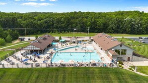 A resort with a large swimming pool, outdoor seating, and a view of the surrounding forest. - White Oak Hollow - newly updated (Innsbrook)