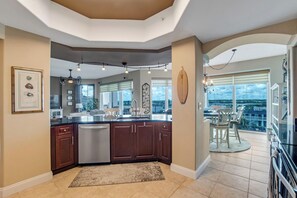 Una cocina moderna con una isla central, armarios de madera oscura y un lavavajillas.