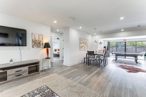 A modern living room with a flat-screen TV, a pool table, and a dining area. - Private Pool & Game Room 6 Mi to Hard Rock Stadium (Hollywood)