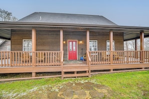A wooden house with a red door, two balconies, and a stone pathway leading to the entrance. - Private Hot Tub & Games Galore! Hamden Family Home (McArthur)